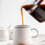 pouring cinnamon coffee into a mug.