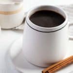 cinnamon coffee and cinnamon sticks on a plate.