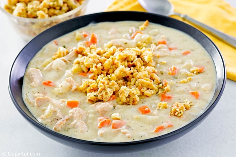 a bowl of creamy turkey soup garnished with crumbled stuffing.