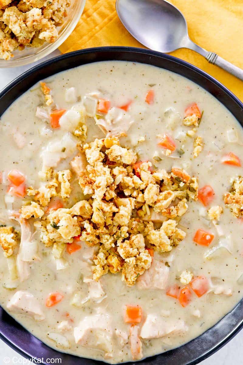 overhead view of a bowl of creamy turkey soup topped with stuffing.