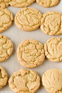 freshly baked gingersnap cookies on a baking sheet.