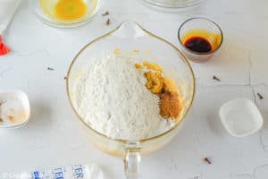 adding dry ingredients to wet ingredients for ginger snap cookies.