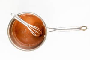 chocolate mixture and a whisk in a saucepan.