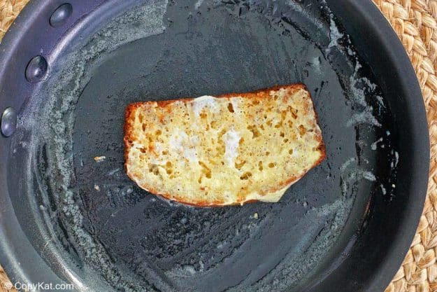 cooking banana bread French toast in a skillet.