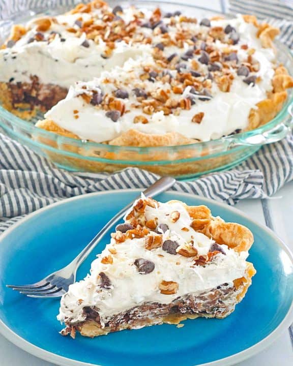 homemade Marie Callender's German Chocolate pie slice on a blue in front of the pie.