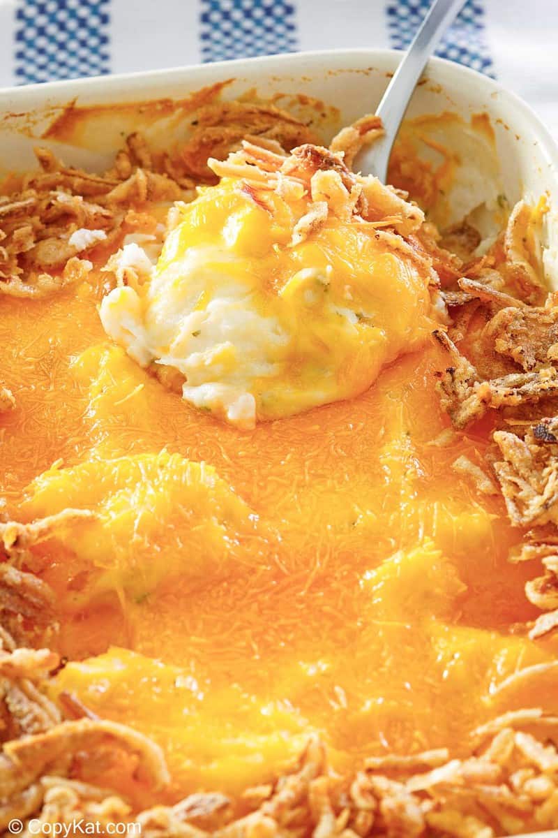 mashed potato casserole topped with cheese and fried onions.