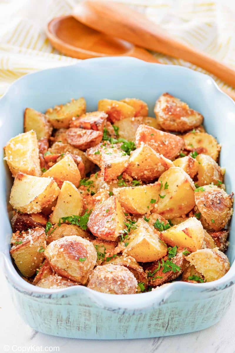 parmesan potatoes in a blue serving dish.