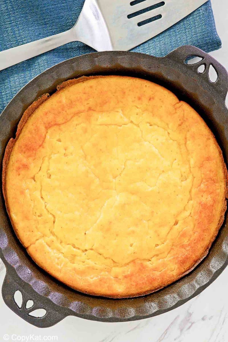 overhead view of sour cream cornbread in a cast iron skillet.