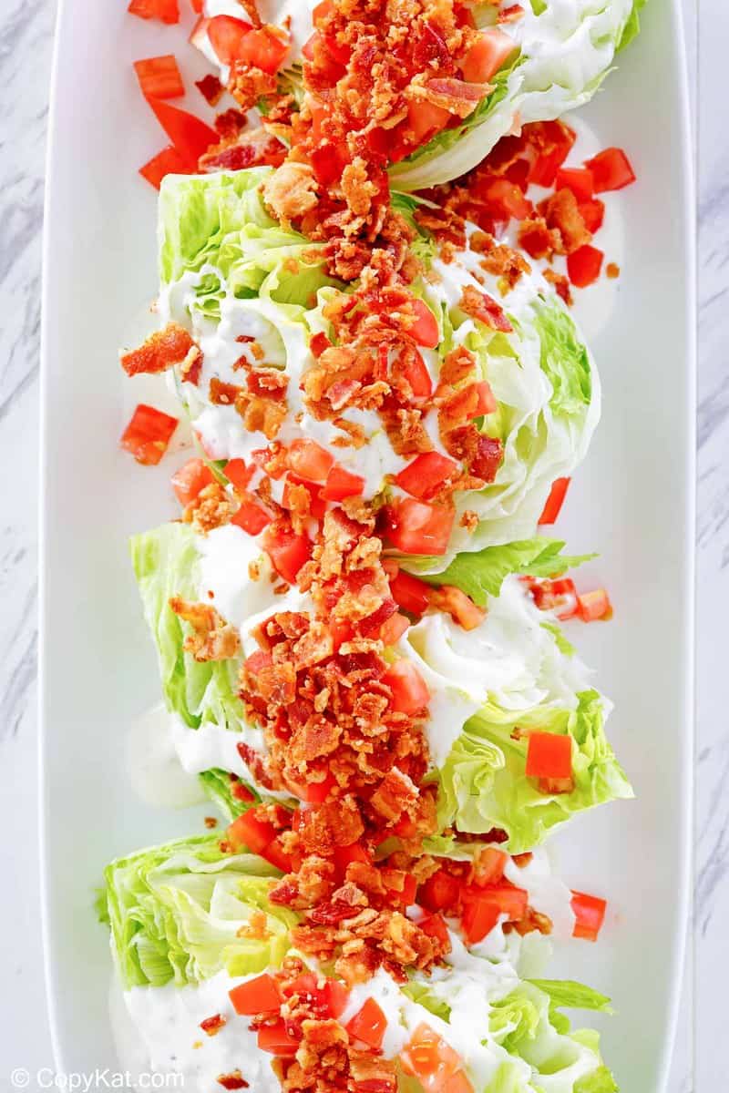 overhead view of 4 wedge salad servings on a platter.