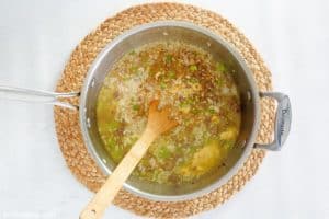 adding rice, cream of chicken soup, and water to a pan for American Chop Suey.