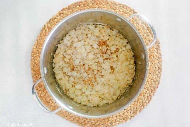 cooked chopped onions and roux for cheeseburger soup in a pot.