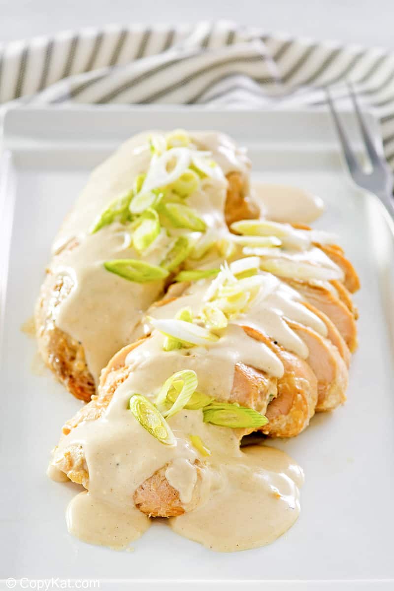 cream cheese chicken topped with green onions on a platter.