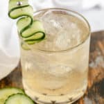 fleur de lis cucumber gin cocktail garnished with cucumber.