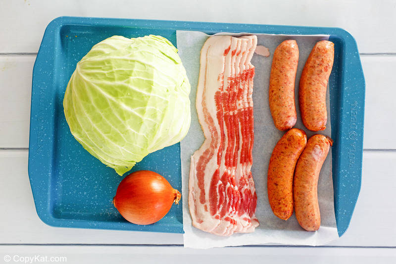fried cabbage with bacon and sausage ingredients on a tray.