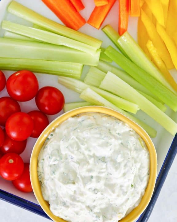 overhead view of green goddess dip and vegetables on a tray.