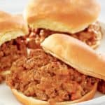 three loose meat sandwiches on a plate.