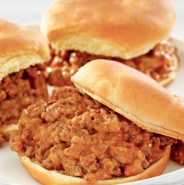 three loose meat sandwiches on a plate.