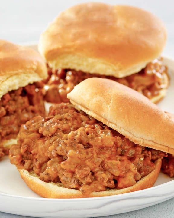 three loose meat sandwiches on a plate.