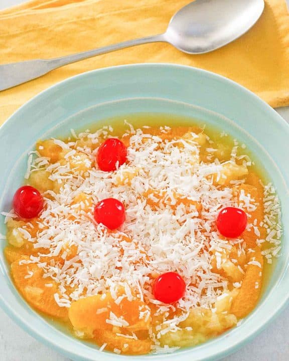 bowl of ambrosia fruit salad and a spoon.