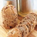 Boston brown bread loaves and cans on a cutting board.
