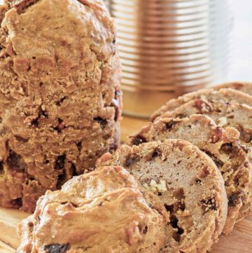 two loaves of Boston brown bread and one is sliced.