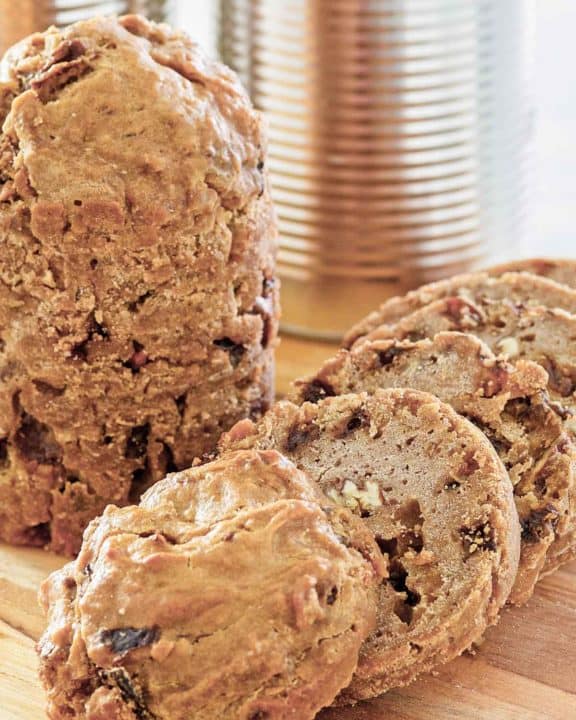 two loaves of Boston brown bread and one is sliced.