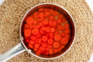 cooking chopped carrots in a saucepan.
