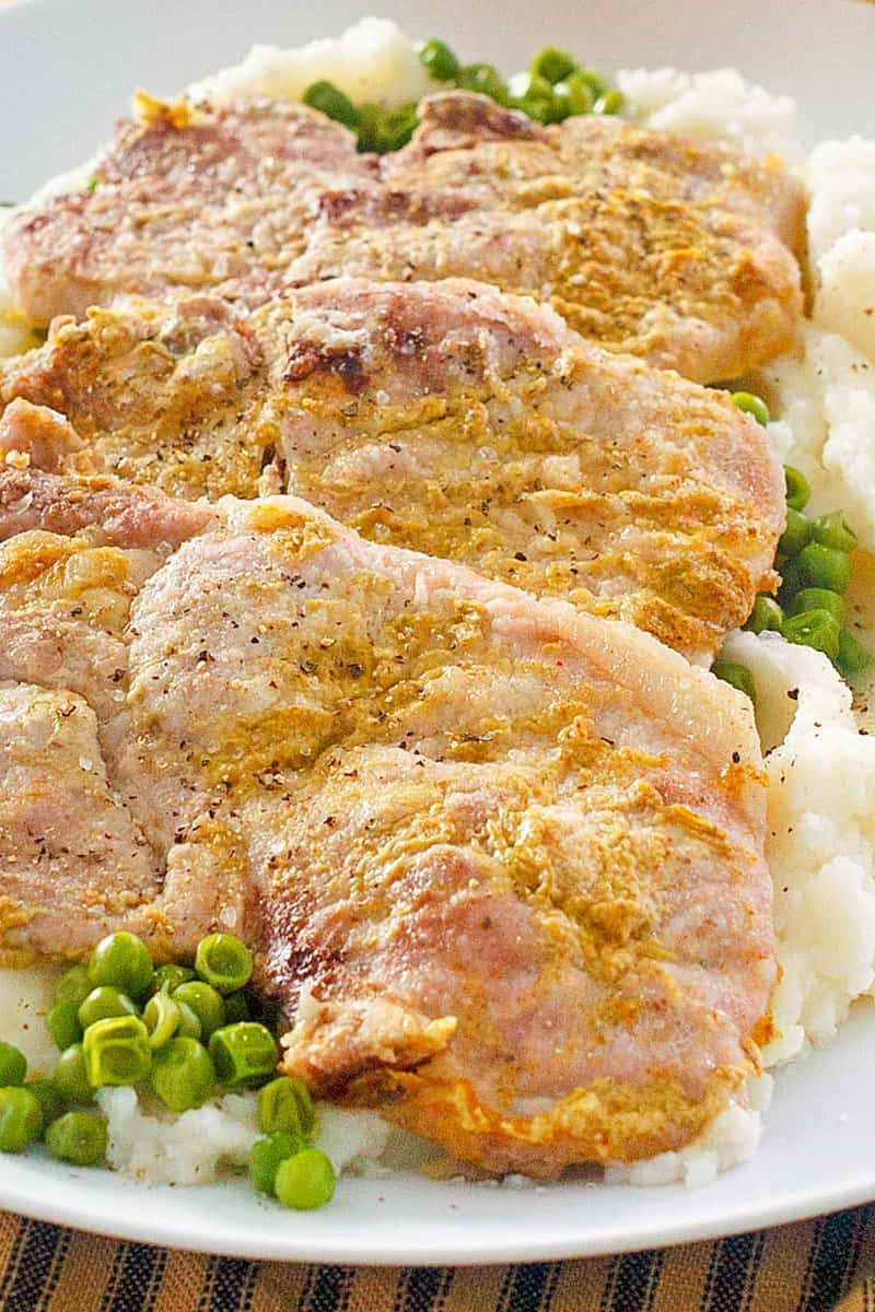 closeup of four baked mustard pork chops.
