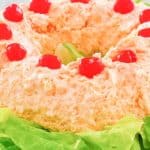 orange fluff jello salad with cherries on top.