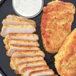 overhead view of pork milanese and lemon caper sauce on a platter.