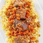 overhead view of braised short ribs over noodles.