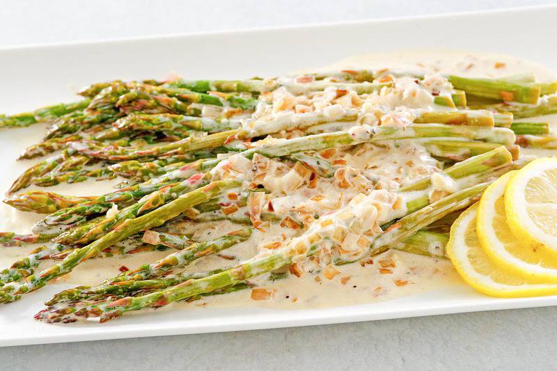 butter sauteed asparagus with lemon cream sauce on a platter.