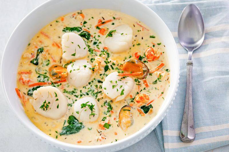 a bowl of seafood bisque and a spoon.