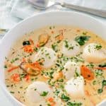 seafood bisque in a bowl and a spoon next to it.