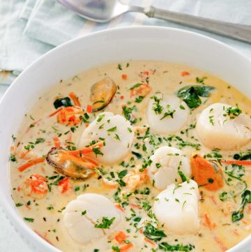 seafood bisque in a bowl and a spoon next to it.