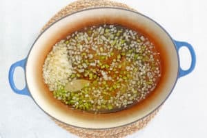 broth, onions, celery, and seasonings in a pot.