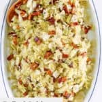 overhead view of boiled cabbage with bacon on a platter.
