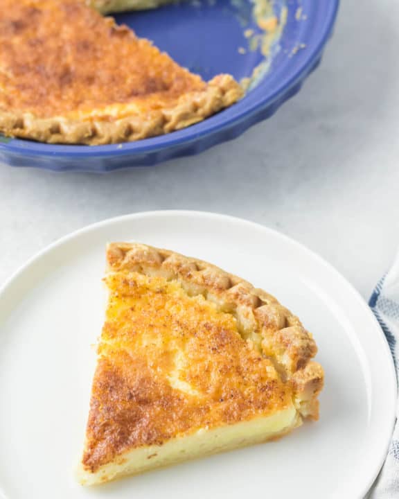buttermilk pie slice on a plate next to the pie.
