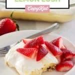 slice of lemon lush dessert and fresh strawberries on a plate.
