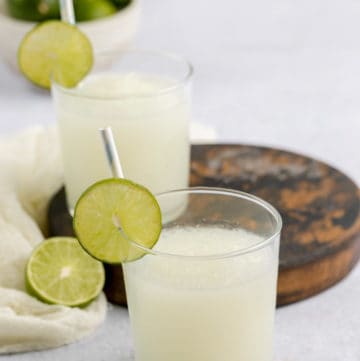 glasses of copycat Taco Bell pina colada frutista freeze and limes.