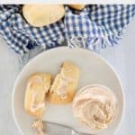 overhead view of copycat Texas Roadhouse cinnamon honey butter in a jar and on a roll.