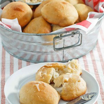 copycat Texas Roadhouse rolls in a metal tub and on a plate.