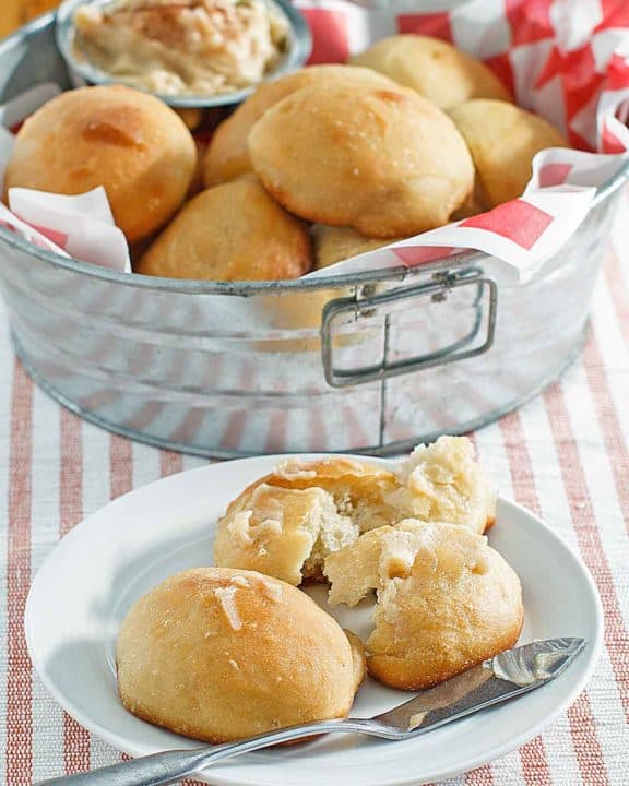 copycat Texas Roadhouse rolls in a metal tub and on a plate.