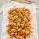 Thai peanut chicken over rice on a platter.