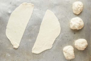 samosa dough balls rolled and cut in half.