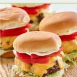 four air fryer hamburgers on a wood board.