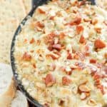 hot bacon and swiss cheese dip in a black dish.