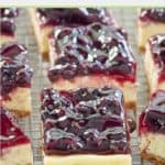 several blueberry cheesecake bars on a wire rack.
