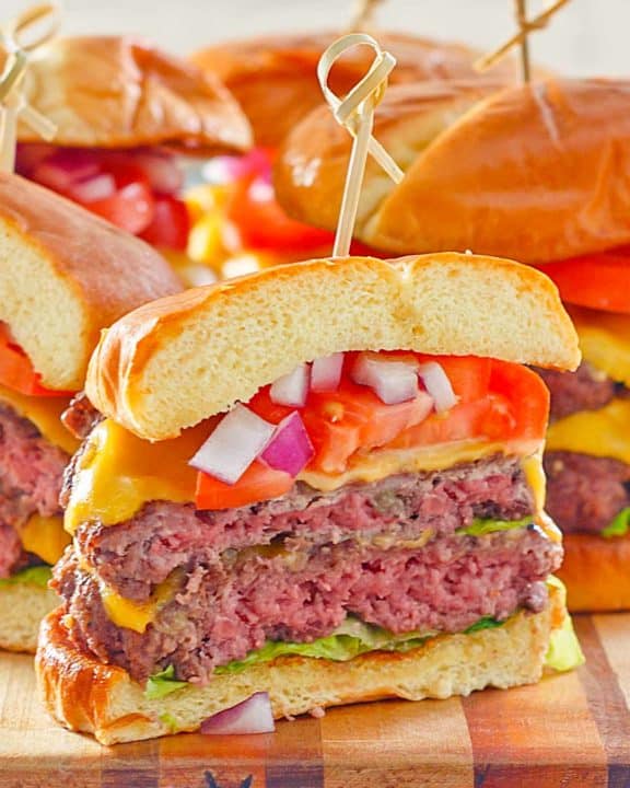 homemade double garlic burger with cheese, lettuce, tomato, and onion.