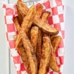 overhead view of a basket of homemade potato wedges.